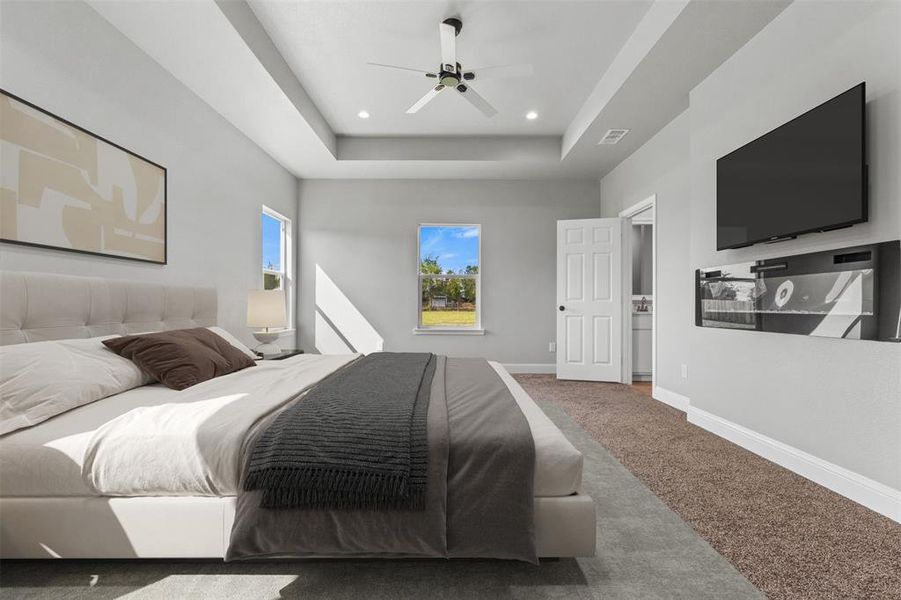 Bedroom with carpet floors, a raised ceiling, ceiling fan, and recessed lighting