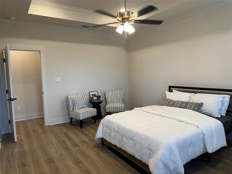 Room featuring crown molding, wood-finish flooring, and a ceiling fan with integrated lighting
