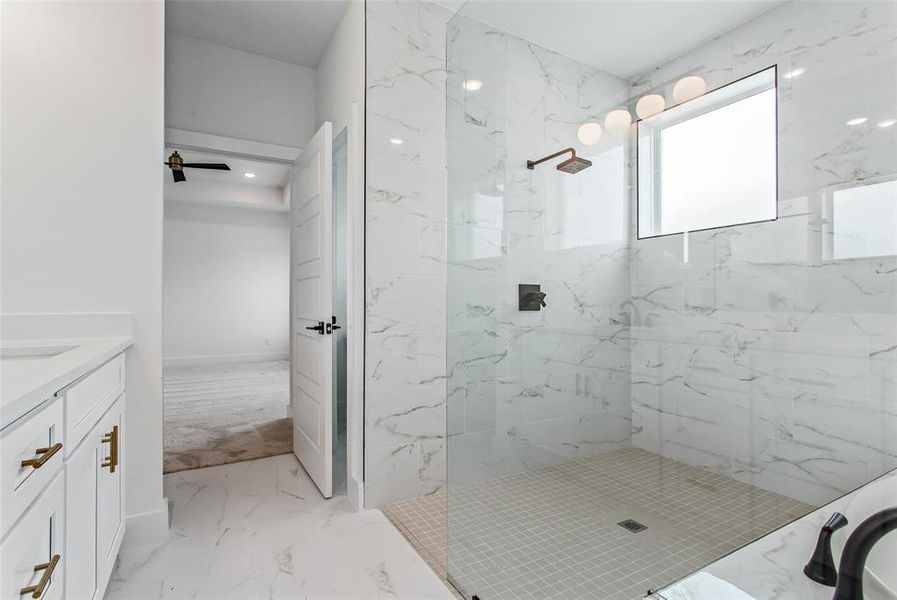 Bathroom featuring vanity, tile patterned flooring, and a tile shower