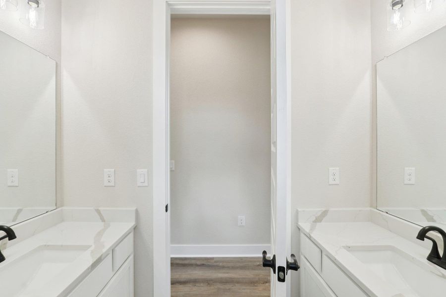 Secondary bathroom featuring dual vanities with quartz countertops and shower/tub combo Secondary bathroom featuring dual vanities with quartz countertops and shower/tub combo
