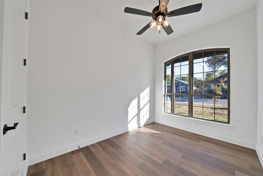 Secondary bedroom featuring dark wood-style flooring and a ceiling fan