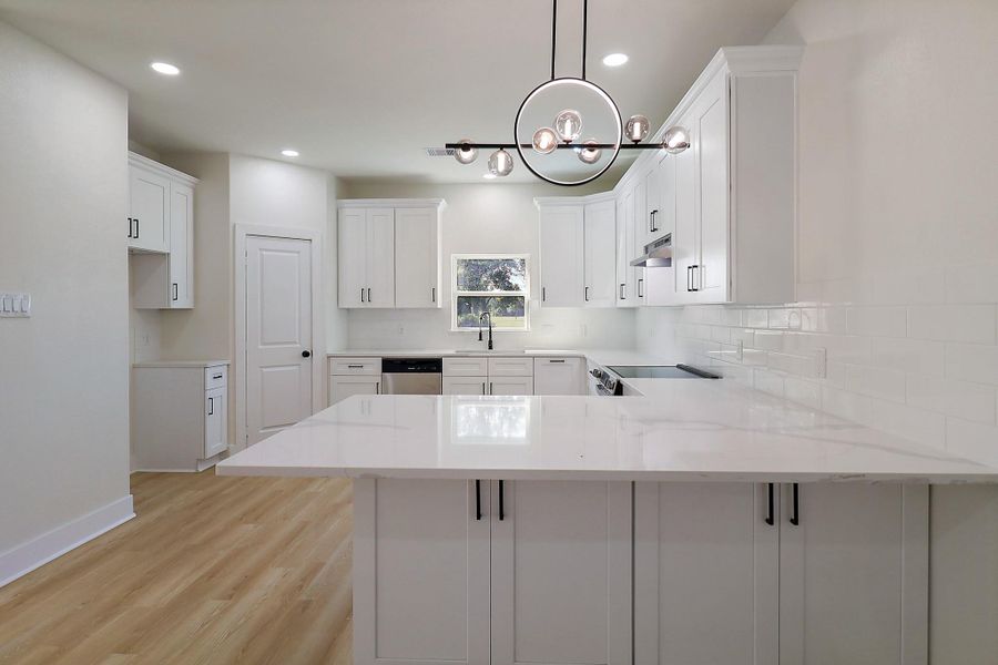 Beautiful cabinetry, countertops and light fixtures add to the elegance.