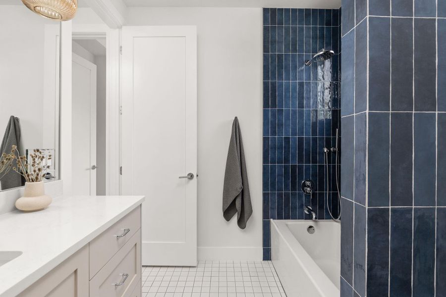 Full bath featuring vanity,  shower combination, and light tile patterned flooring