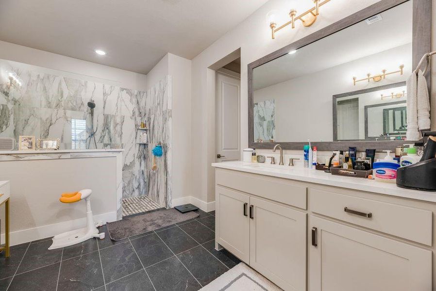 Full bathroom featuring vanity and a marble finish shower