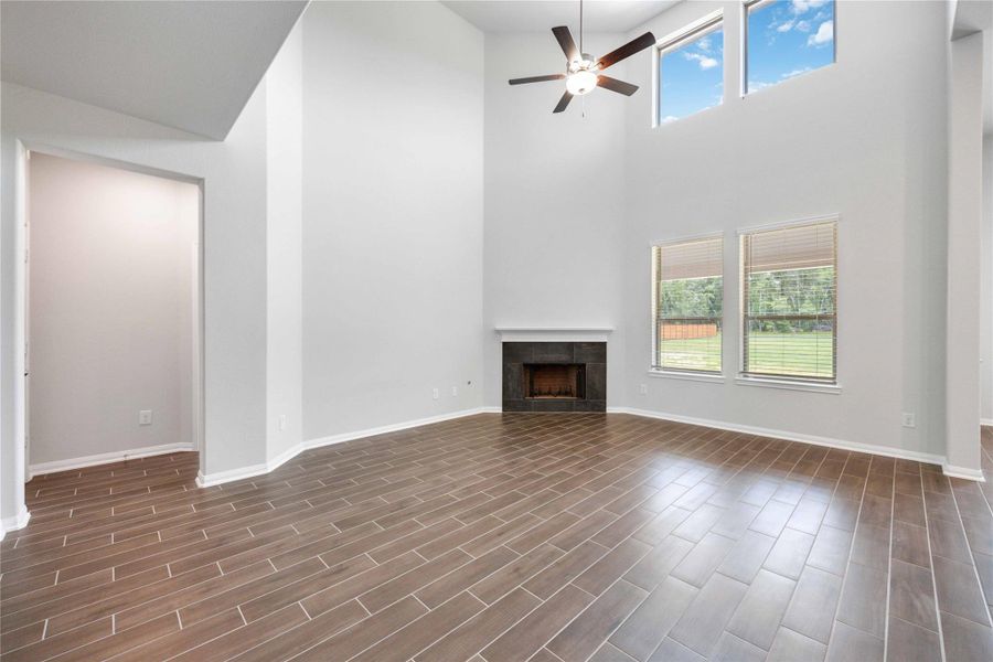 The expansive family room features two-story ceilings and windows and an upgraded fireplace for cozy winter nights.