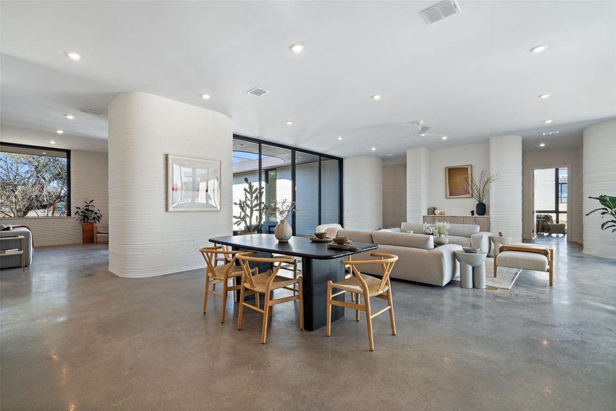 Dining space featuring expansive windows, a healthy amount of sunlight, and concrete flooring