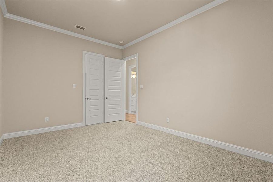 Unfurnished bedroom with carpet floors and crown molding