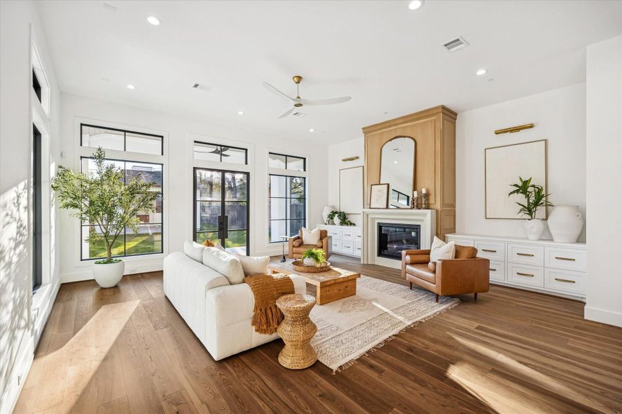 Main living room is framed by tall windows and glass doors that draw in natural light and connect directly to the backyard. The generous footprint and centered fireplace create a comfortable gathering space designed for both daily living and entertaining. **Previous build by Arch Angelo** Main living room is framed by tall windows and glass doors that draw in natural light and connect directly to the backyard. The generous footprint and centered fireplace create a comfortable gathering space designed for both daily living and entertaining. **Previous build by Arch Angelo**