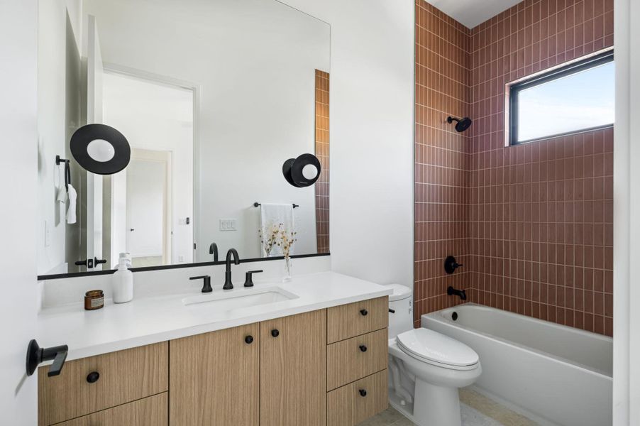 Clean lines and vertical wall tile define this modern bathroom with a warm wood vanity.