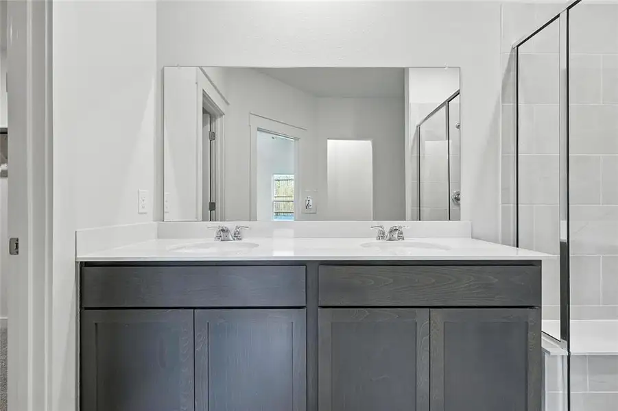 Bathroom with double vanity and a shower stall