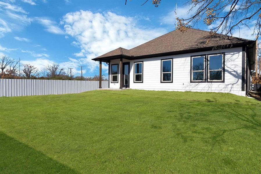 Back of house with a shingled roof and a patio area