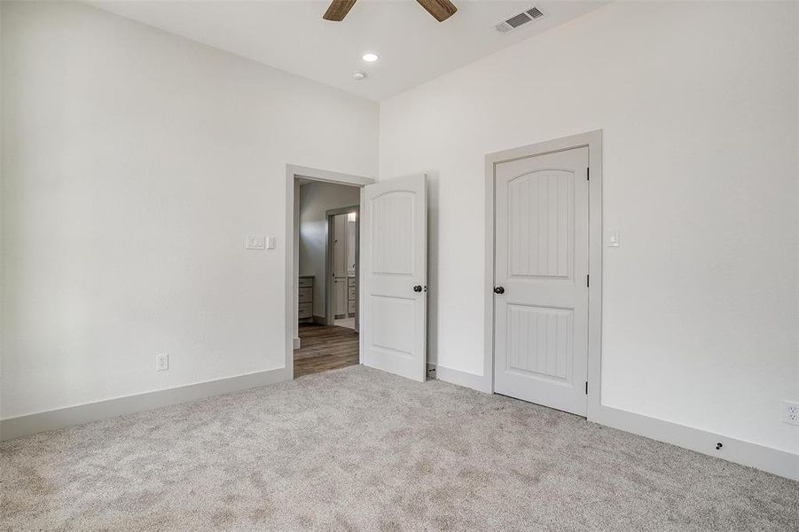 Unfurnished bedroom with ceiling fan and carpet floors