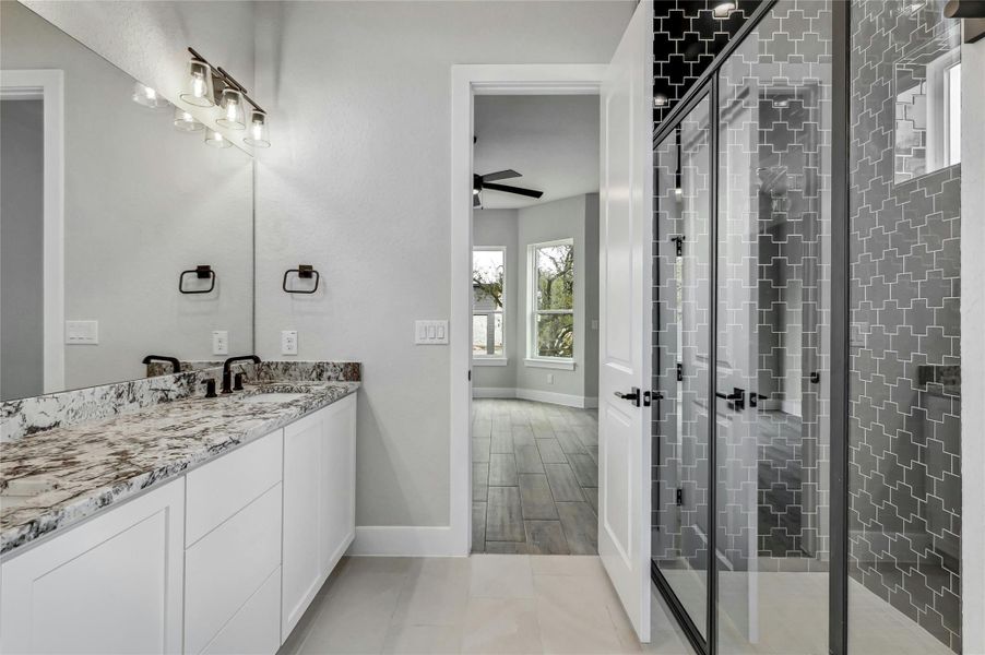 Bathroom with a stall shower, baseboards, ceiling fan, vanity, and wood finish floors