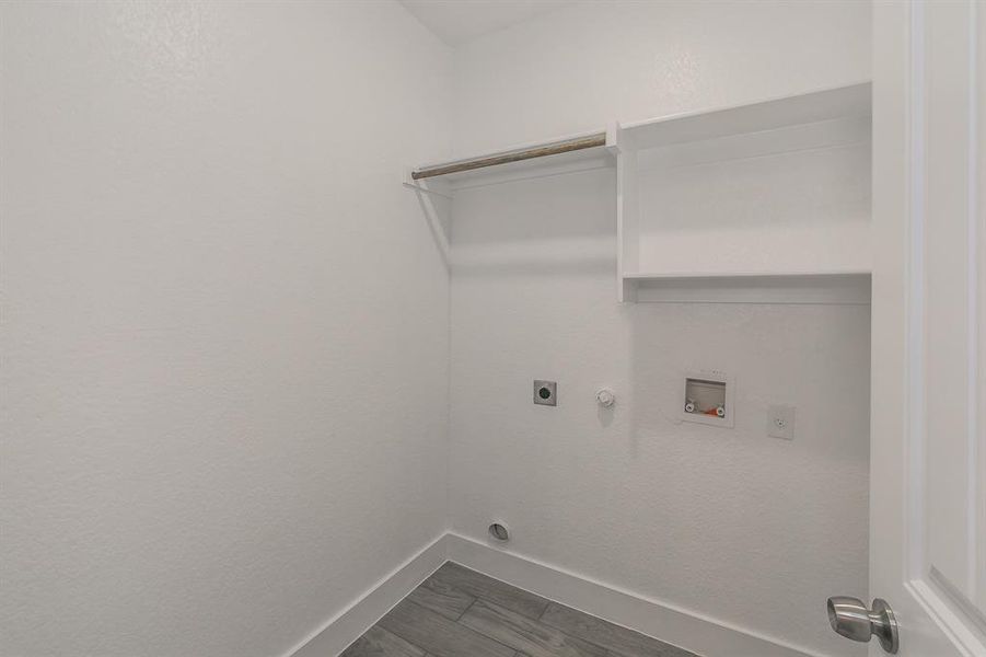 Washroom featuring electric dryer hookup, hookup for a gas dryer, washer hookup, and hardwood / wood-style flooring