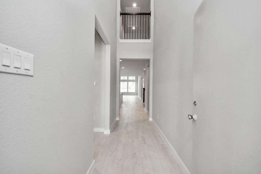As you step into the threshold of this luxurious home, you'll soon be welcomed by an elegant glass door (to be installed). Inside, soaring ceilings amplify the spaciousness, while the refined wood-look tile flooring and oversized baseboards exude sophistication and charm. Sample photo of completed home with similar floor plan. Actual colors and selections may vary.