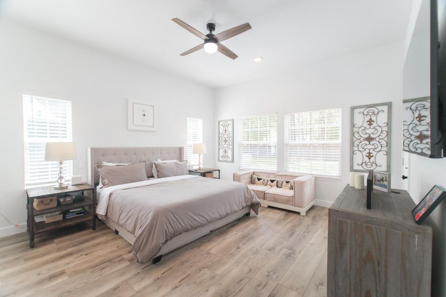 The primary suite offers a tranquil escape, featuring a tray ceiling with recessed lighting, a ceiling fan, and huge windows The primary suite offers a tranquil escape, featuring a tray ceiling with recessed lighting, a ceiling fan, and huge windows