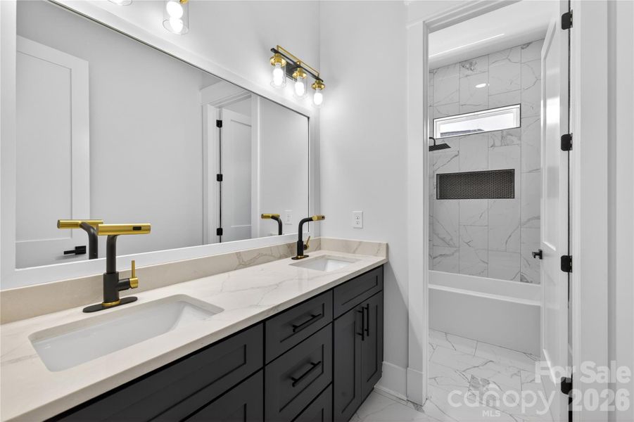 From the oversized double vanity to the custom tile work and designer fixtures, every detail in this bathroom feels elevated
