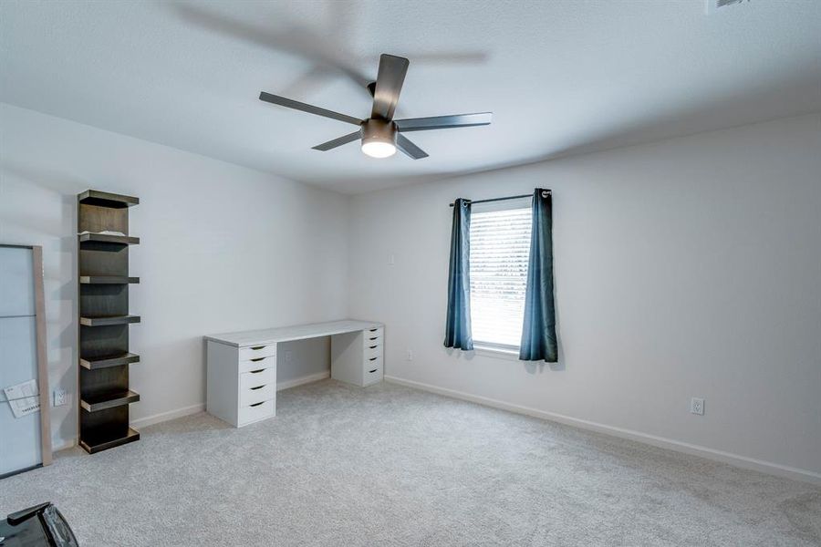 Unfurnished office featuring light carpet and ceiling fan