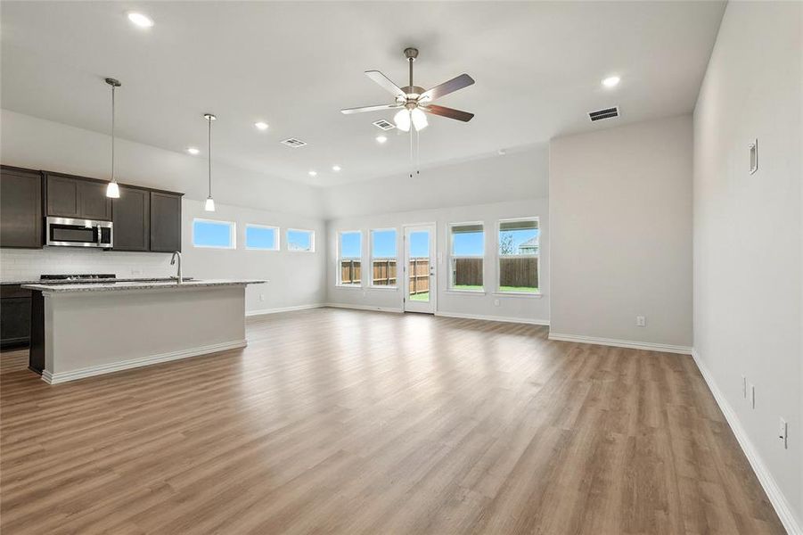 Unfurnished living room with healthy amount of natural light, recessed lighting, light wood-style floors, and a ceiling fan