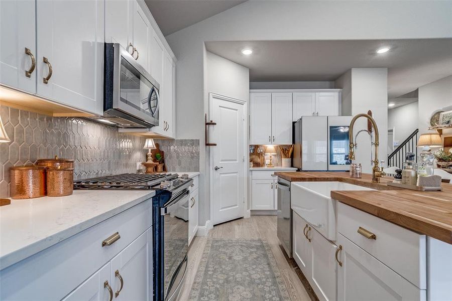 Kitchen featuring white cabinetry, stainless steel appliances, decorative backsplash, and recessed lighting Kitchen featuring white cabinetry, stainless steel appliances, decorative backsplash, and recessed lighting