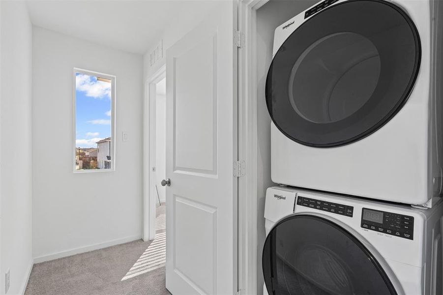 Laundry area with carpet and stacked washer / drying machine