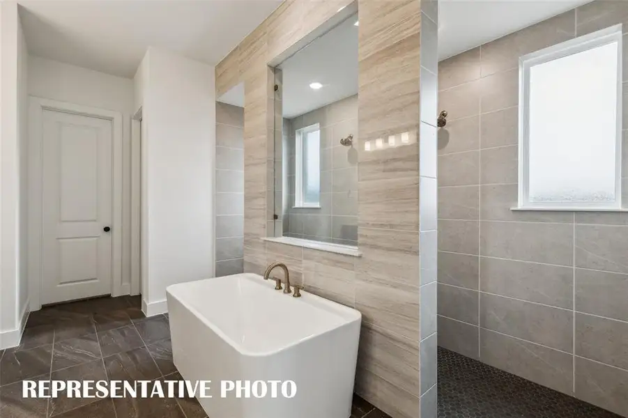 Enjoy a spa like experience every day in our signature bath with double walk through shower and free standing tub.  REPRESENTATIVE PHOTO