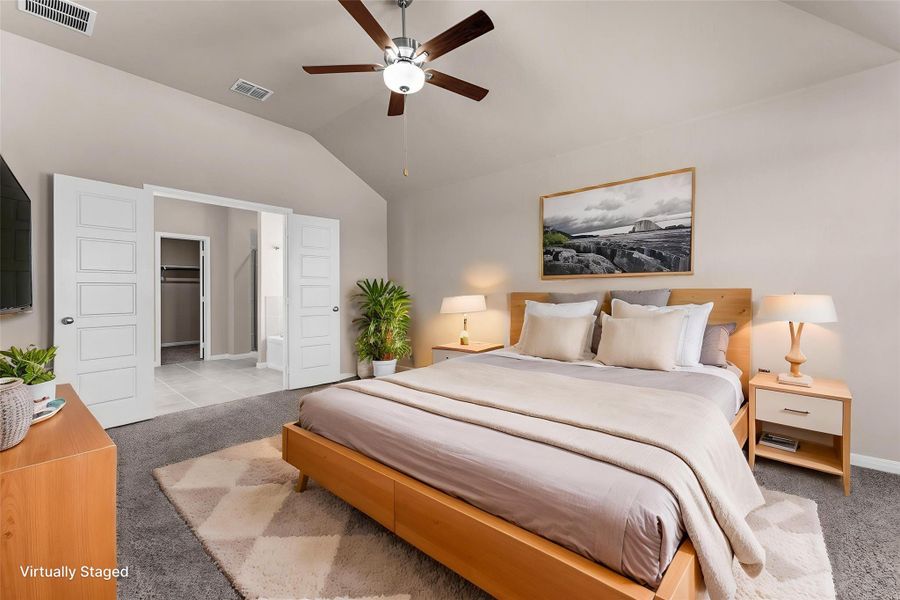 Relax in this well-lit bedroom featuring vaulted ceilings and direct access to a private bathroom and walk-in closet.