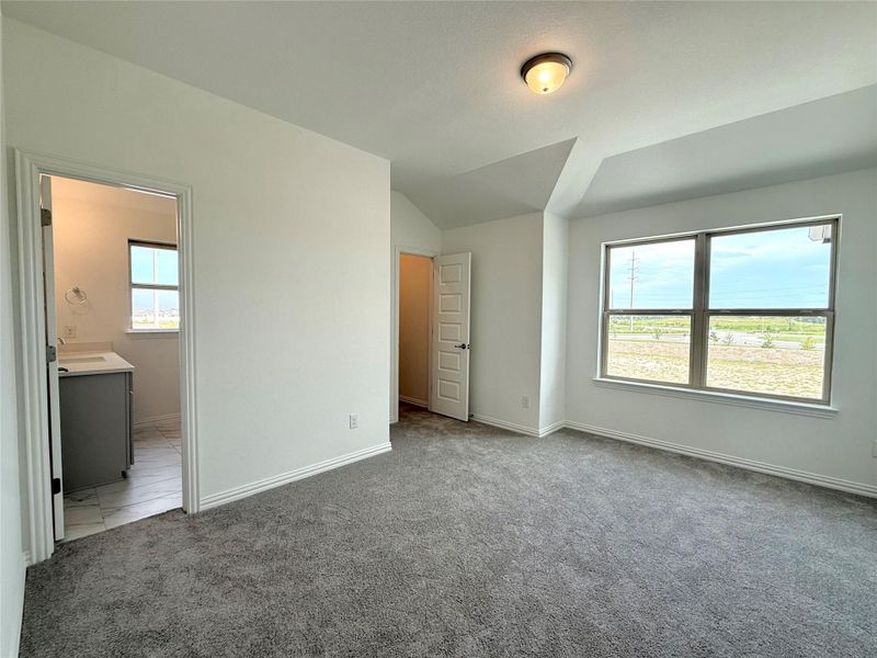 Unfurnished bedroom featuring carpet floors, vaulted ceiling, and ensuite bathroom Unfurnished bedroom featuring carpet floors, vaulted ceiling, and ensuite bathroom