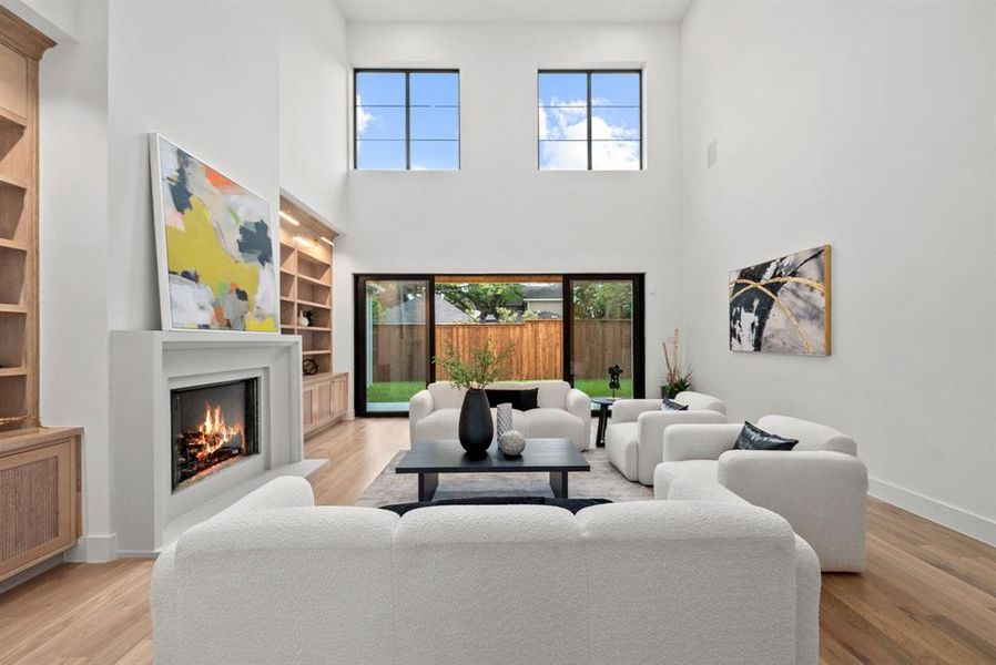 This living space features high ceilings, hardwood flooring, and a fireplace