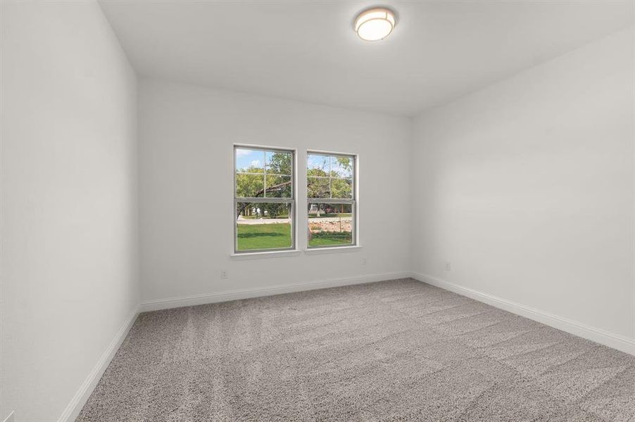 Empty room featuring light carpet and baseboards