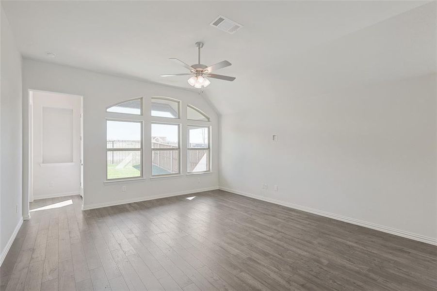 Unfurnished room featuring ceiling fan, dark wood-style flooring, and lofted ceiling