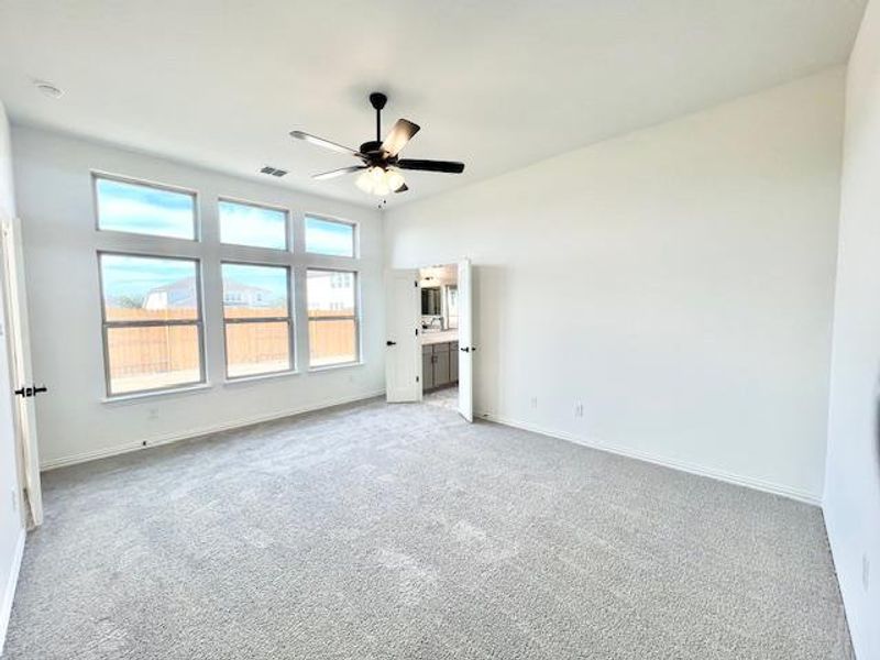 Unfurnished bedroom with light carpet, visible vents, baseboards, and a ceiling fan Unfurnished bedroom with light carpet, visible vents, baseboards, and a ceiling fan