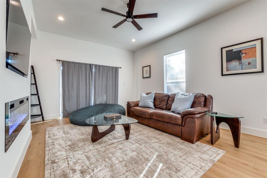Living room featuring ceiling fan and light hardwood / wood-style flooring
