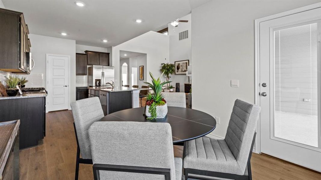 Dining area featuring wood-finish flooring and a white paneled door with an integrated glass panel Dining area featuring wood-finish flooring and a white paneled door with an integrated glass panel