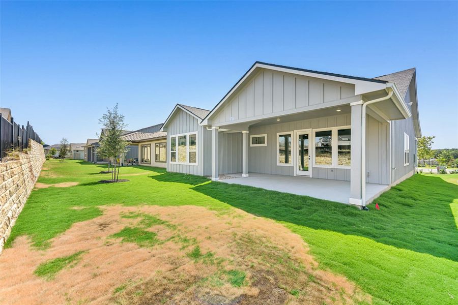 Rear view of house with board and batten siding and a patio area Rear view of house with board and batten siding and a patio area