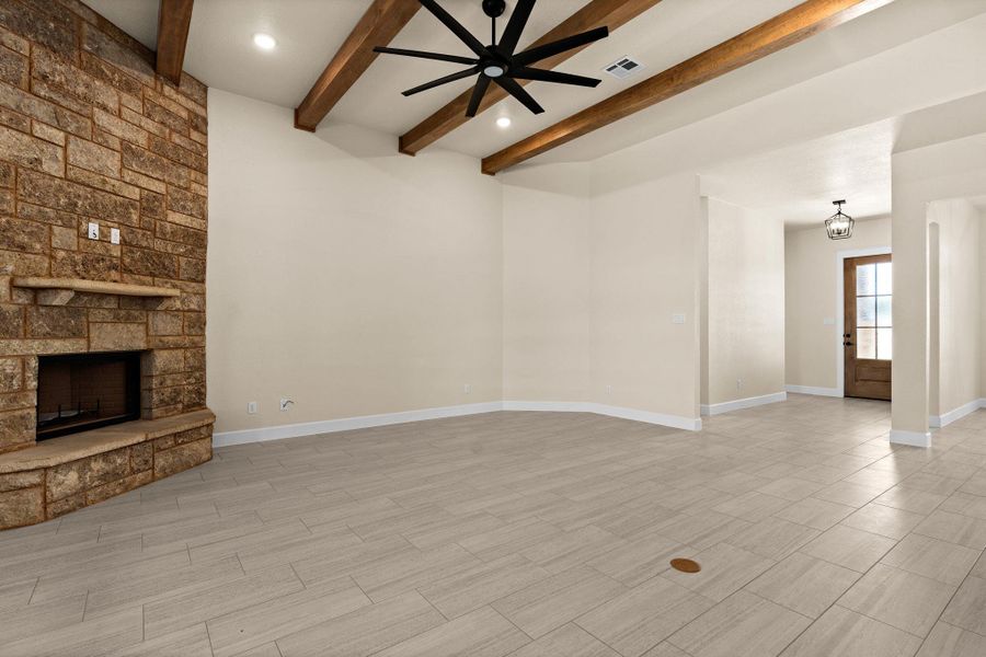 Unfurnished living room featuring a stone fireplace, wood tiled floors, beamed ceiling, a ceiling fan, and recessed lighting Unfurnished living room featuring a stone fireplace, wood tiled floors, beamed ceiling, a ceiling fan, and recessed lighting