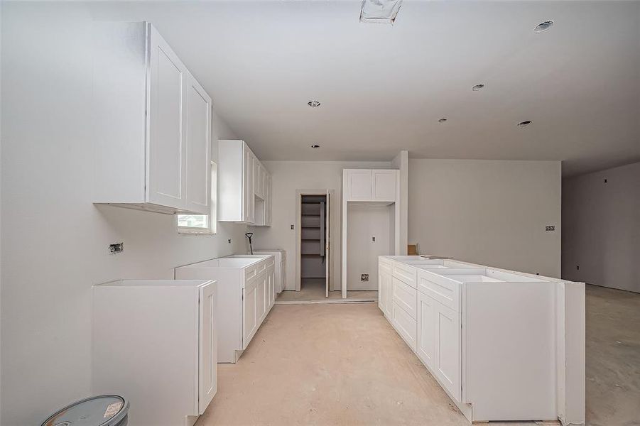 A chef’s dream in the making—this kitchen will feature an island for extra workspace, extensive cabinetry for organization, and ample countertop space ready to accommodate culinary creations. Appliance spaces are already set, awaiting their finishing touches.