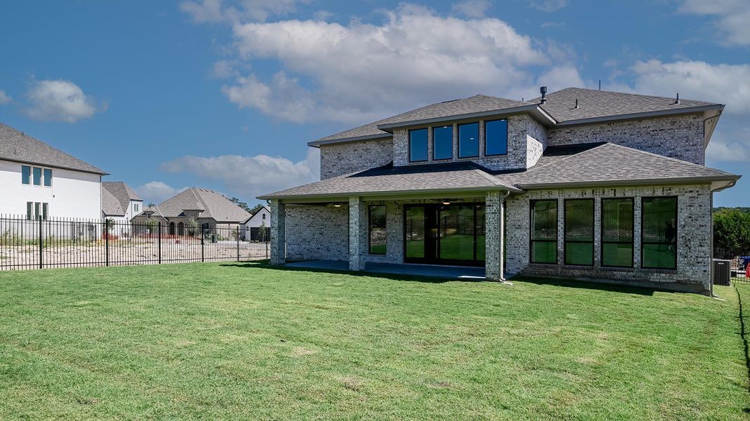 Rear view of property featuring a shingled roof, brick siding, a patio, and a residential view Rear view of property featuring a shingled roof, brick siding, a patio, and a residential view
