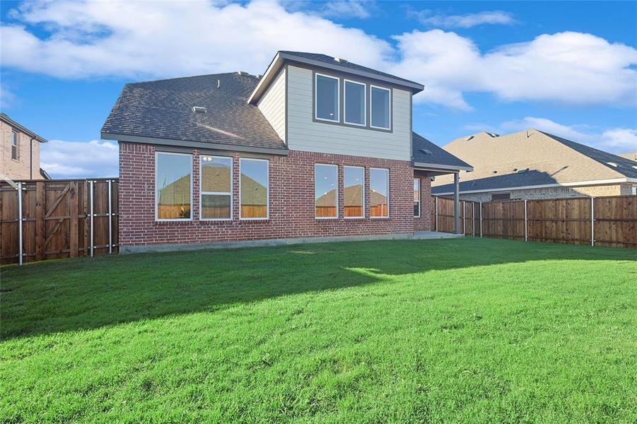 Back of house with a patio area and a yard