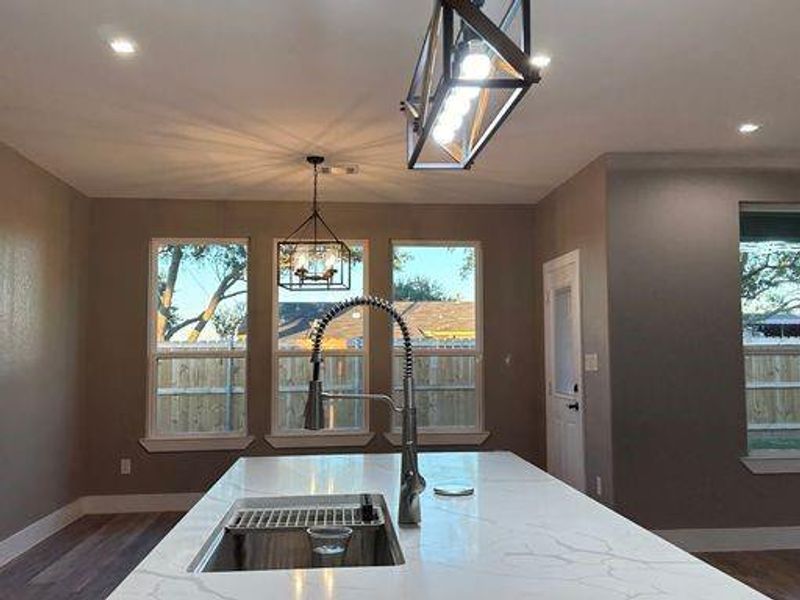 Kitchen with plenty of natural light, an inviting chandelier, pendant lighting, and sink