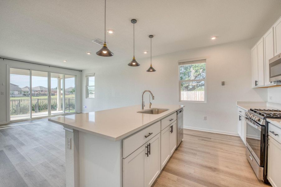 An open floor plan connects the modern kitchen directly to the bright living space.