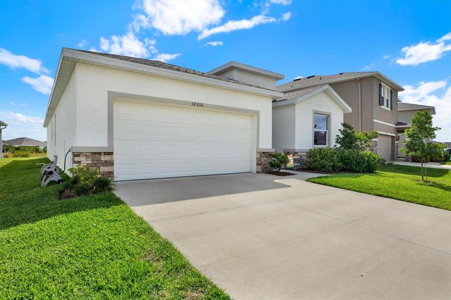 Front exterior of a new home in Woodcreek, Wesley Chapel, FL, highlighting curb appeal (Image 28).