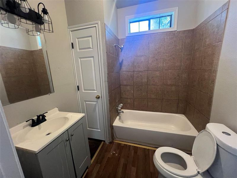 Bathroom featuring vanity, dark wood-style floors, and bathing tub / shower combination Bathroom featuring vanity, dark wood-style floors, and bathing tub / shower combination