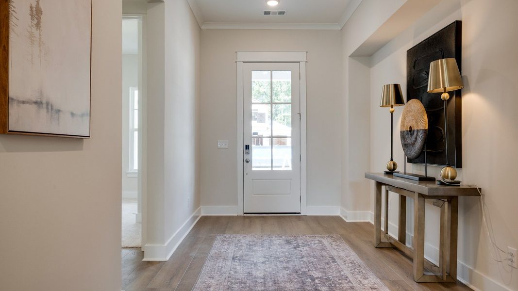 Front door leading into hallway with hardwood flooring