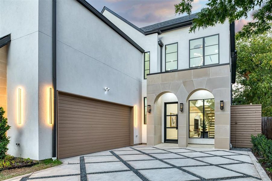 View of front of house with stucco siding and concrete driveway
