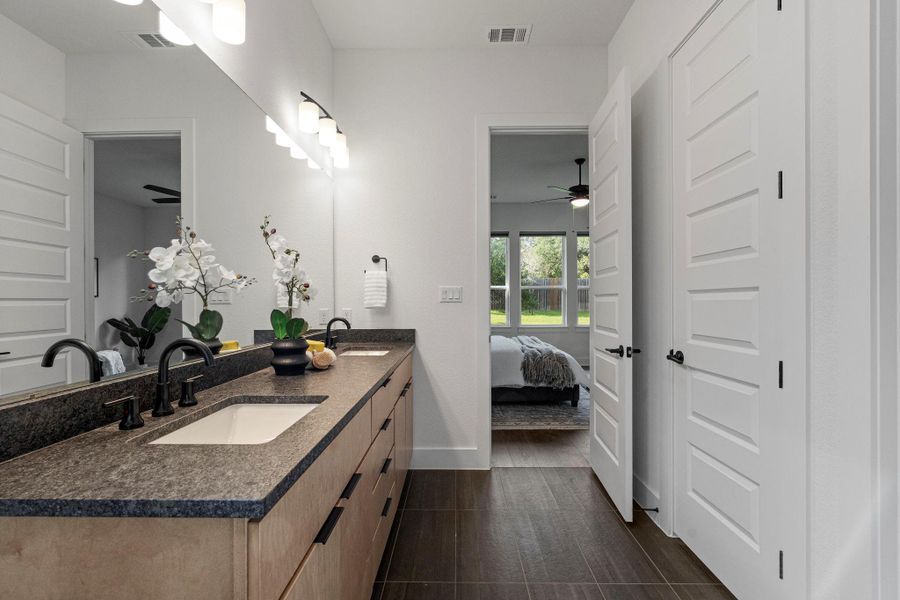 Double vanity with sleek counters offers practical elegance in this modern bathroom.