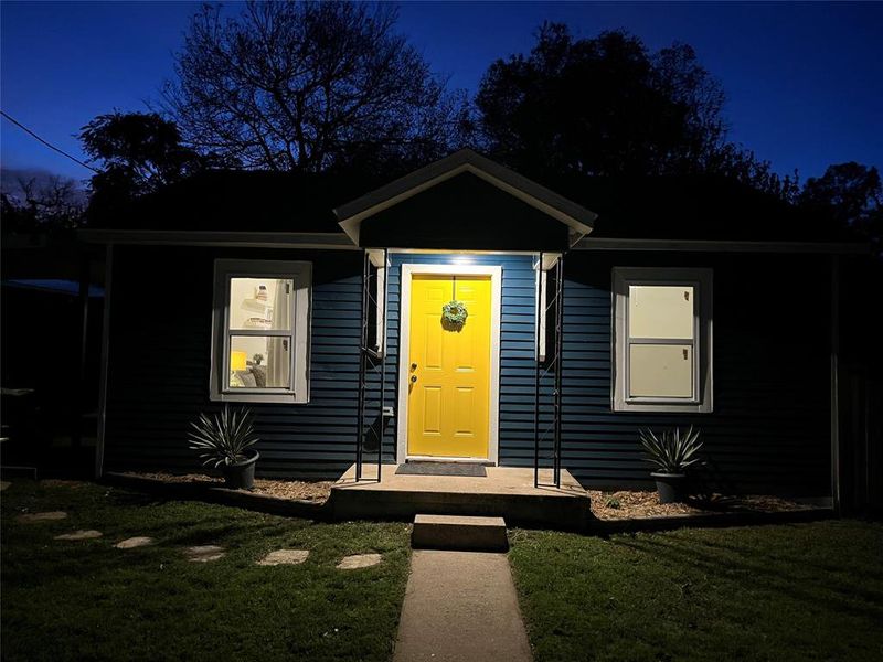 Charming blue siding exterior featuring a bright yellow front door with a decorative wreath