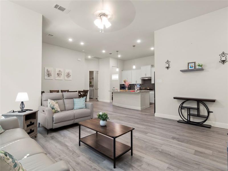 Living area featuring recessed lighting, baseboards, light wood finished floors, visible vents, and a ceiling fan