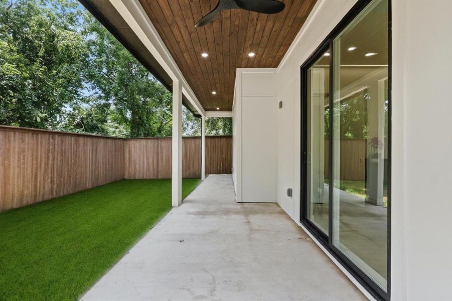 Fenced backyard featuring ceiling fan and a patio