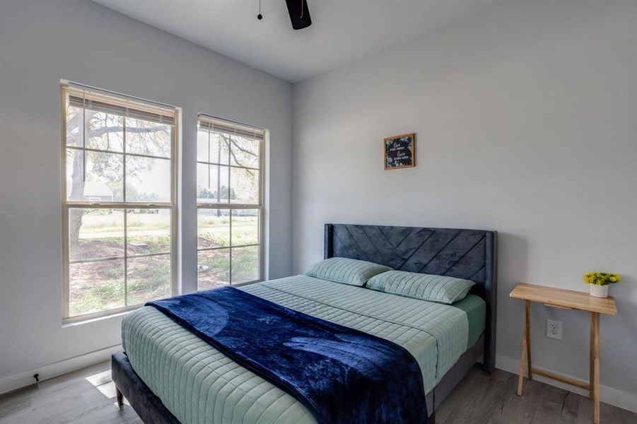 Bedroom featuring wood finished floors and a ceiling fan Bedroom featuring wood finished floors and a ceiling fan